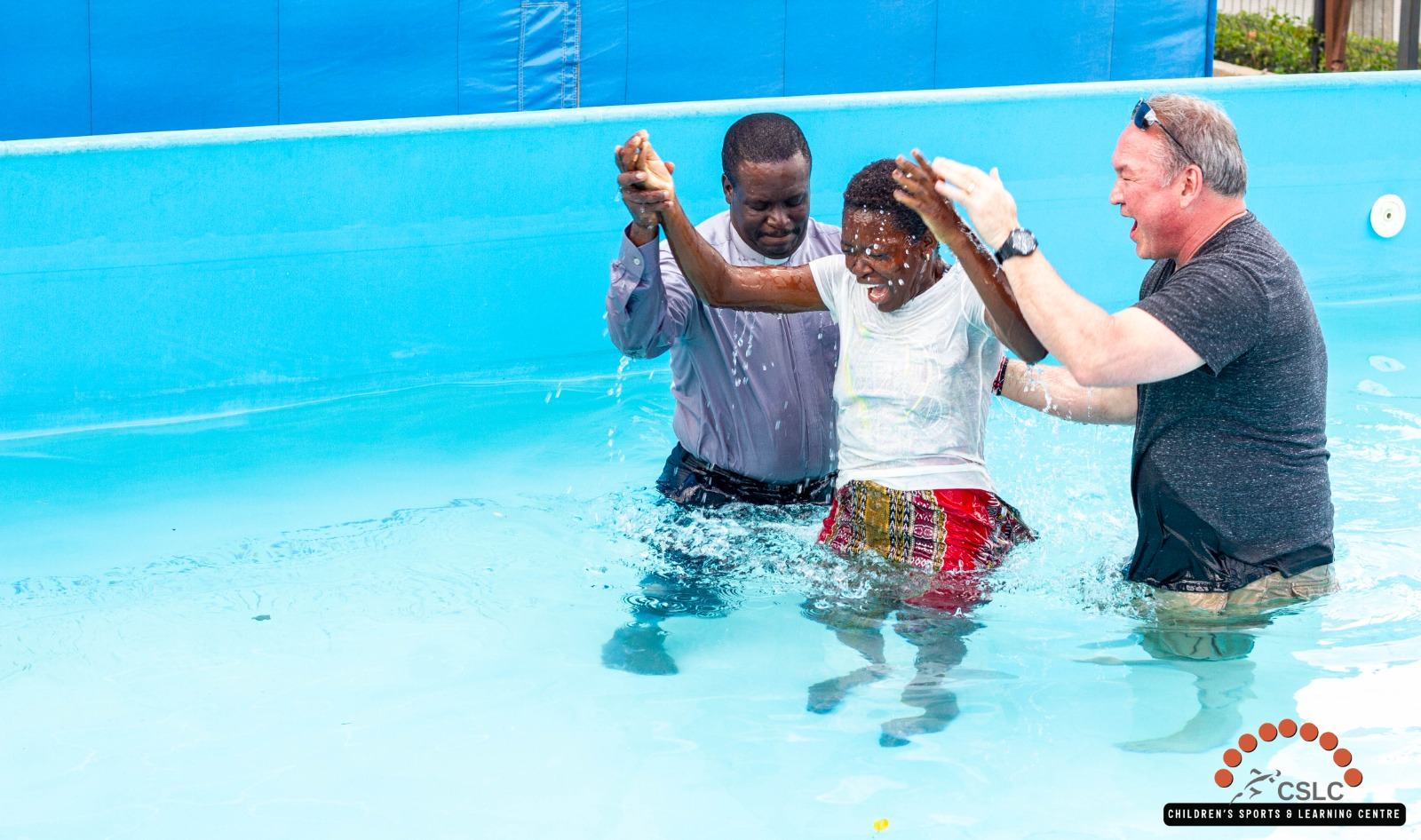 A young woman celebrating with leaders during her baptism