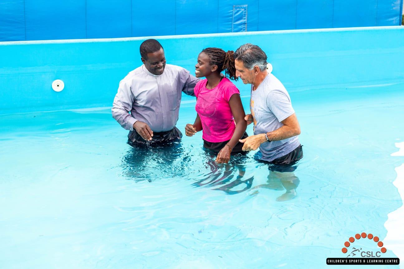 Church leaders and a volunteer sharing a baptism moment with a young woman