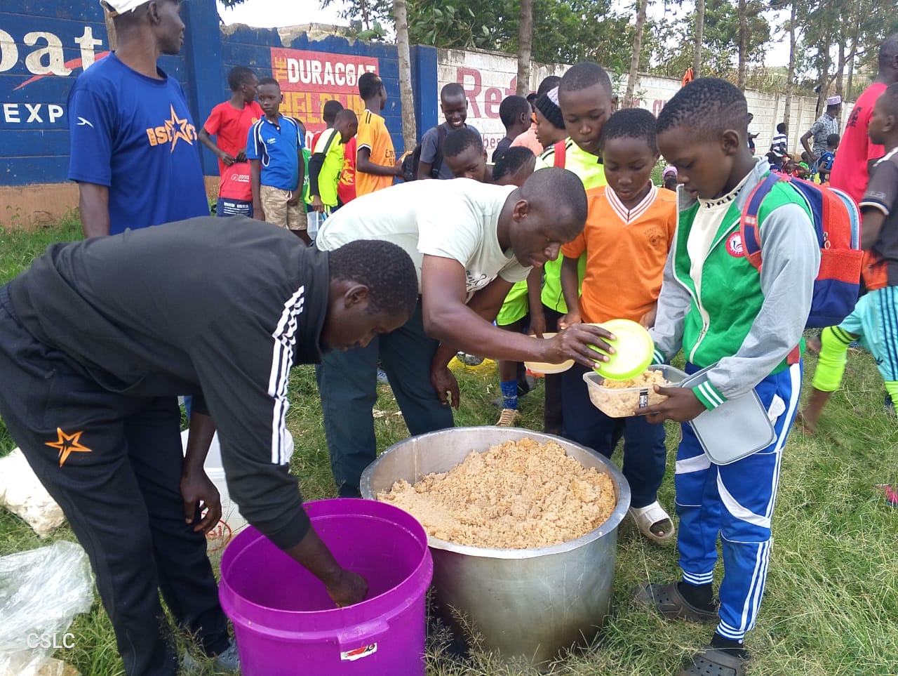 Volunteers serving a hot meal to children after a sports session